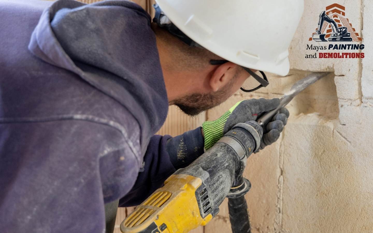 A worker using a hammer drill for light chipping work.