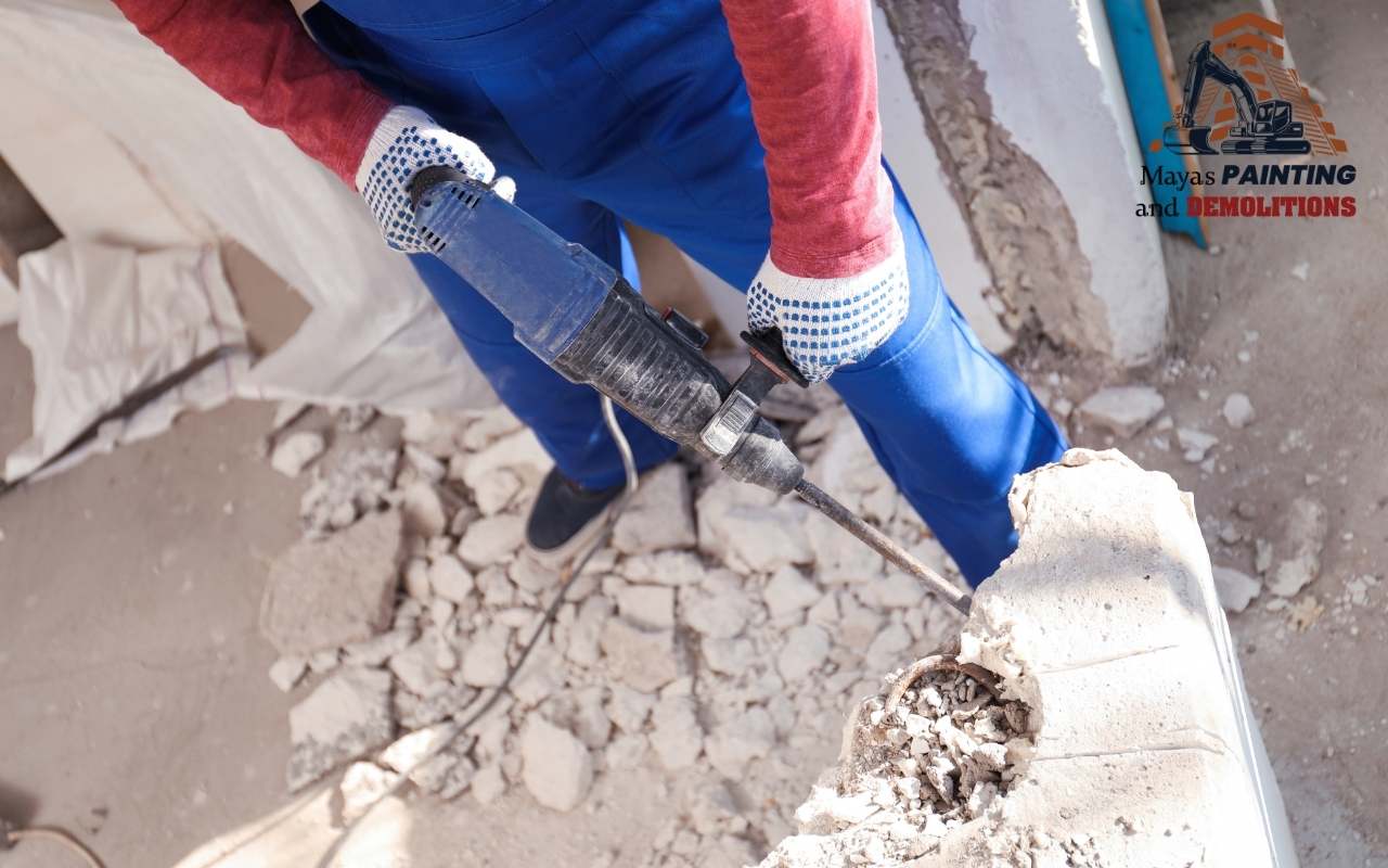 A technician applying lubricant to a demolition hammer for maintenance.